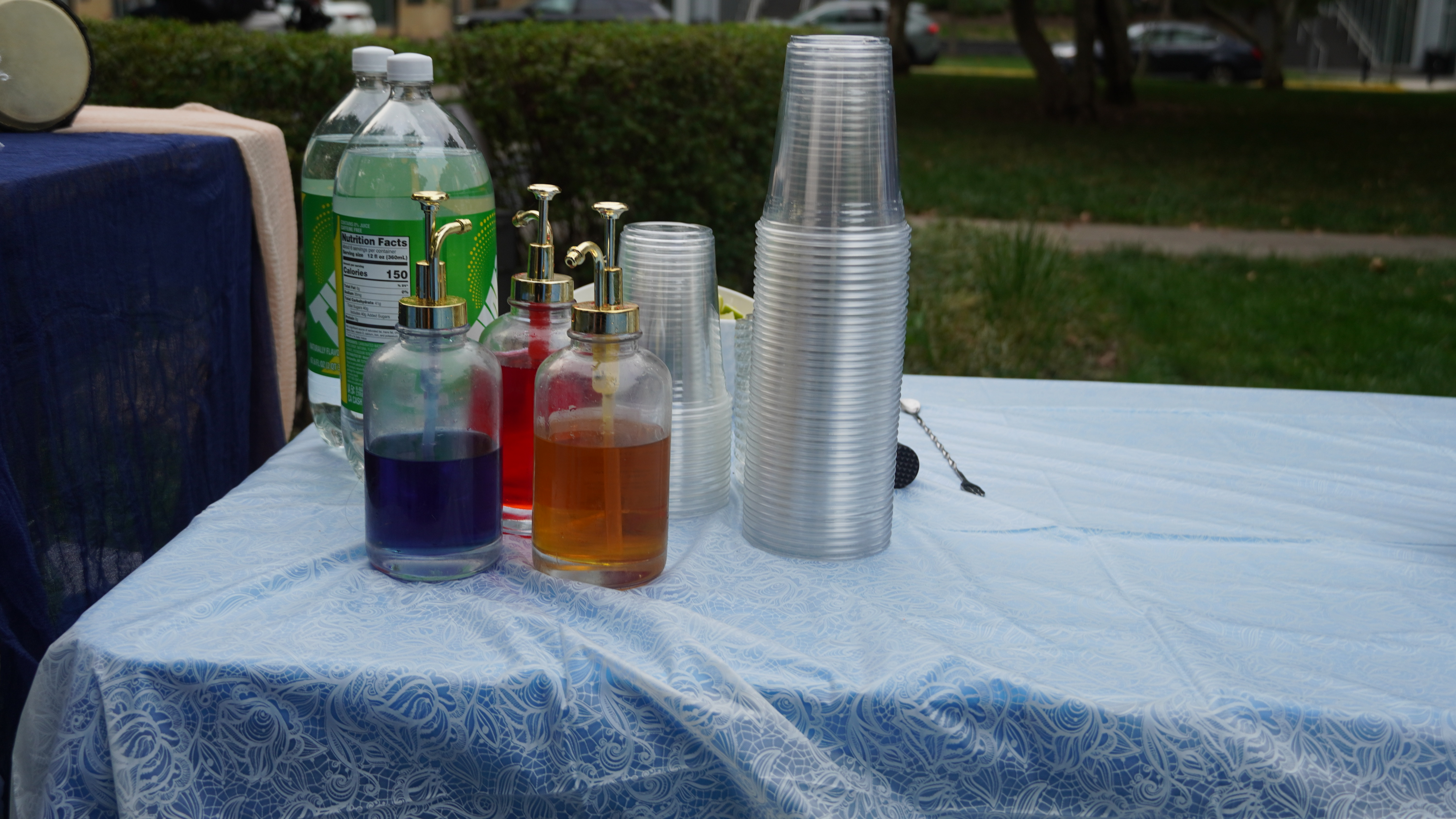 Outdoor beverage station with colorful syrups and drinks